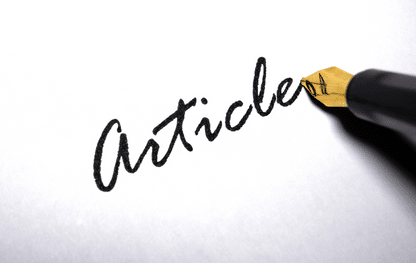 Pióro piszące słowo ‘article’ na białej kartce