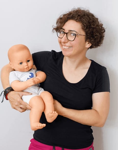 Joanna Nawrocka-Rohnka, fizjoterapeutka pediatryczna, trzyma lalkę niemowlęcia na rękach.