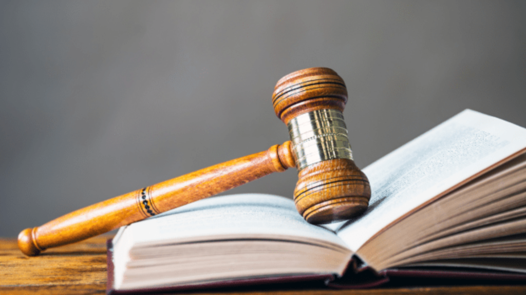 Drewniany młotek sędziowski leżący na otwartej księdze