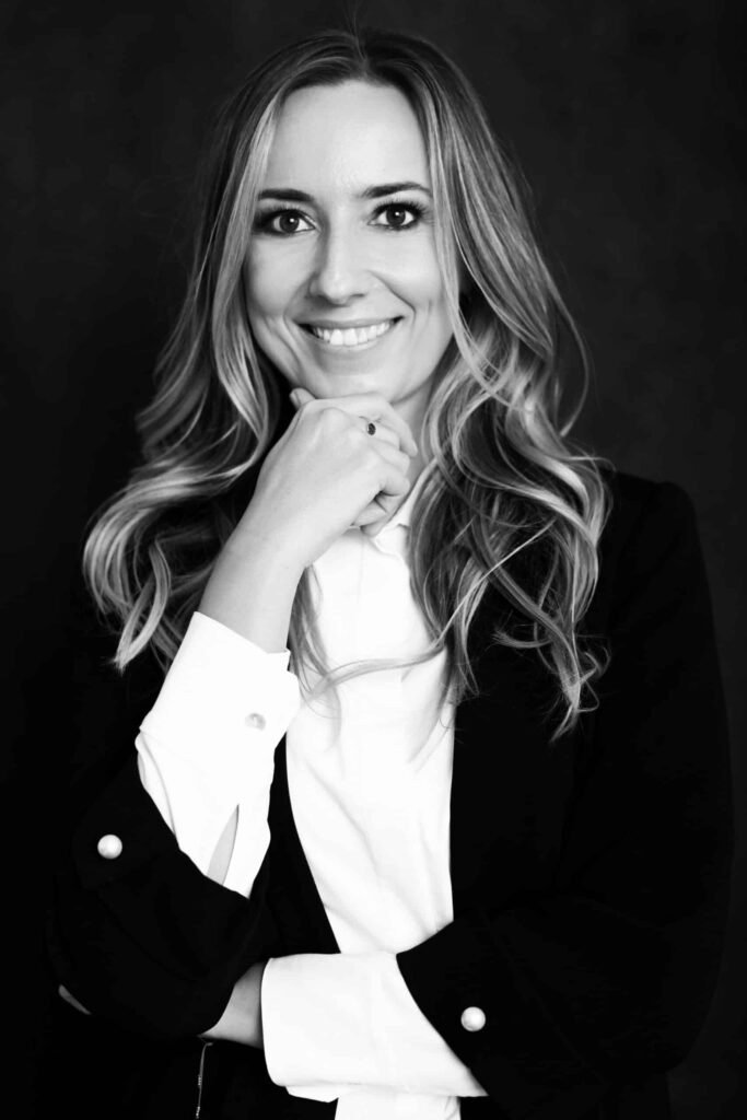 Lilianna Kasprzyk, adwokat, stoi z dłonią pod brodą.