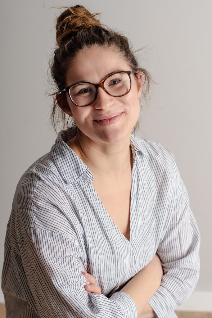 Zuzanna Mańko, psycholożka i psychoterapeutka w trakcie certyfikacji, siedzi i uśmiecha się.