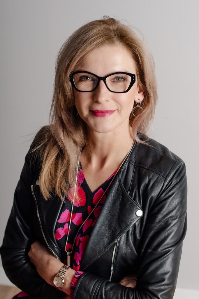 Bożena Siminiak, psycholożka i psychoterapeutka systemowa, stoi i uśmiecha się.